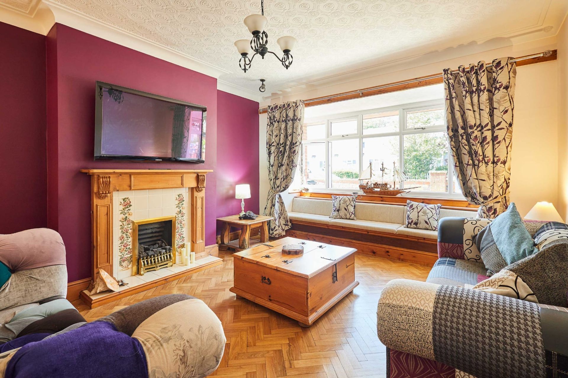 Spacious lounge at Sandcastle House Skegness with bay window seat, fireplace and patchwork sofas