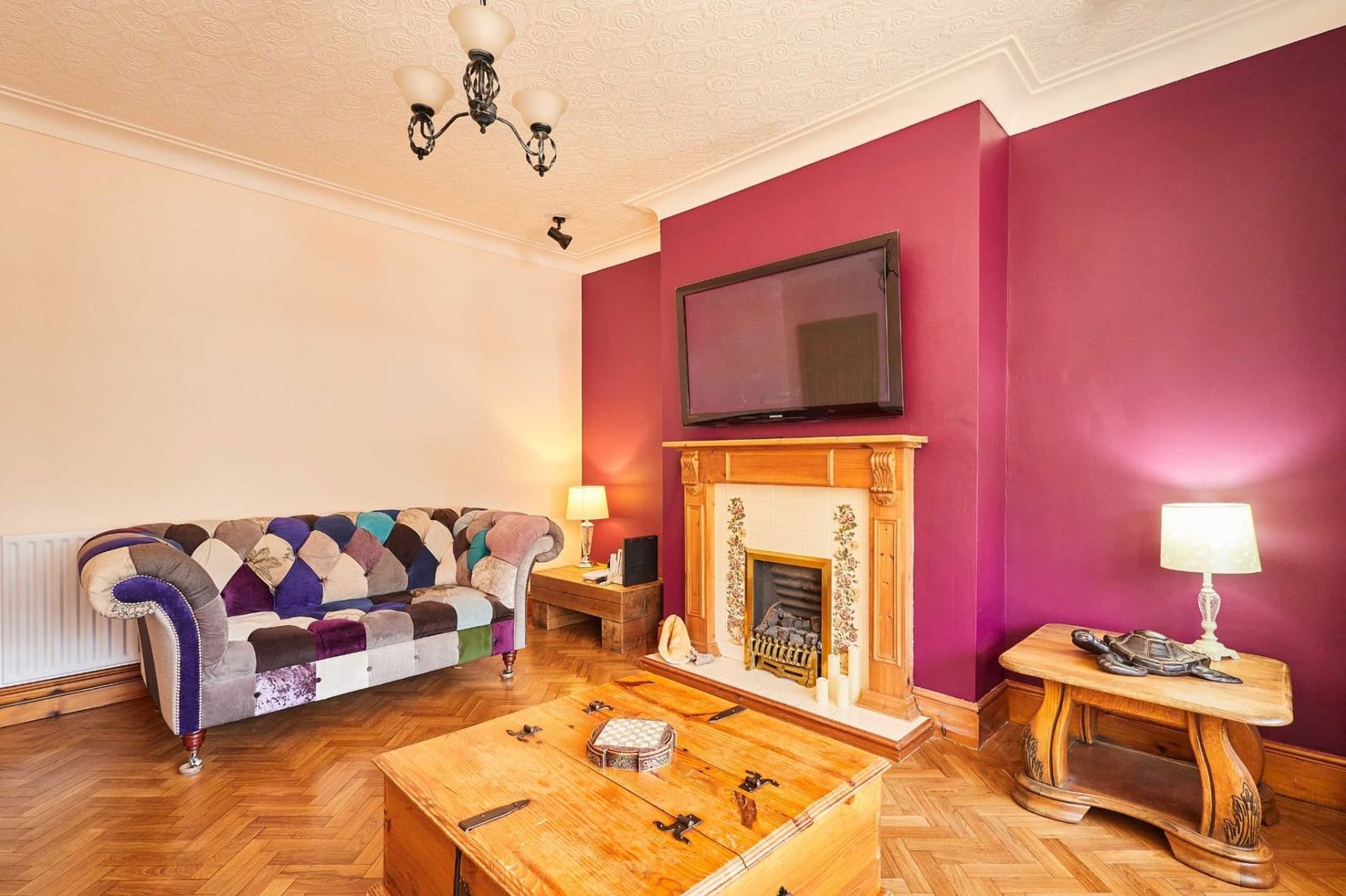 Second sitting room with feature fireplace and parquet floor, perfect for cosy evenings